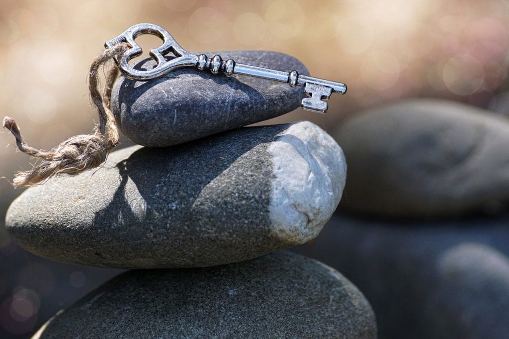 a decorative key sits on tumbled stones