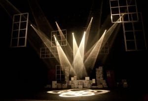 A stage is lit with dramatic lighting, waiting for the performers make their entrance