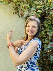 woman showing her bandaid where the Moderna vaccine was administered